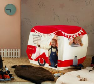 Two children playing in a mini camper.